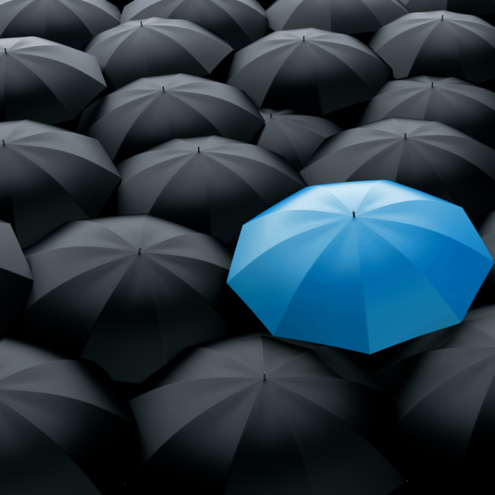 blue umbrella amongst all black ones